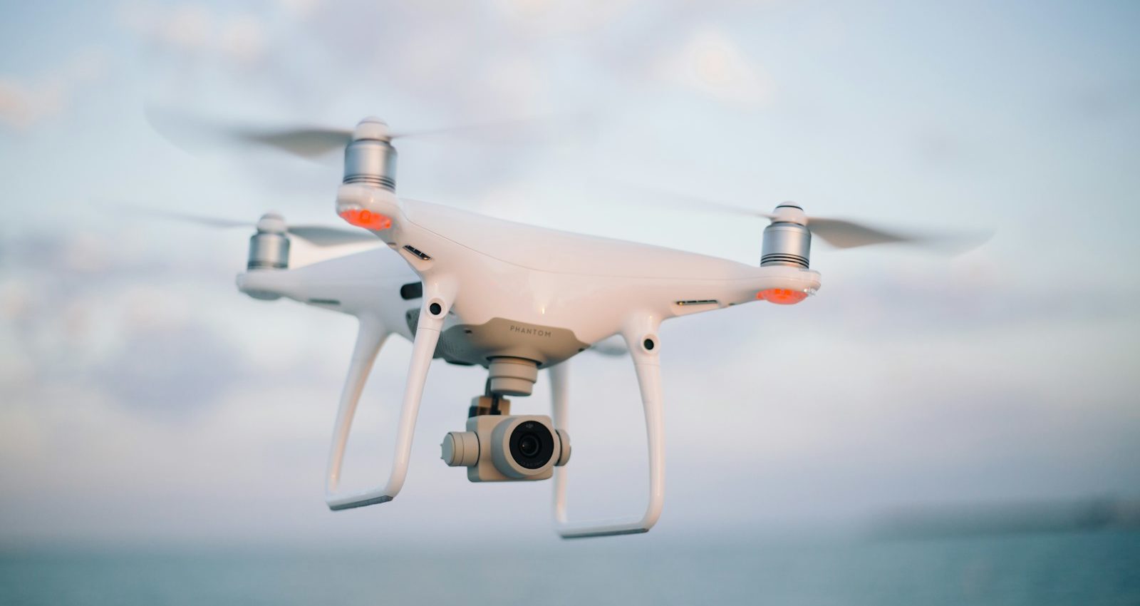 close up photography of drone flying over body of water at daytime